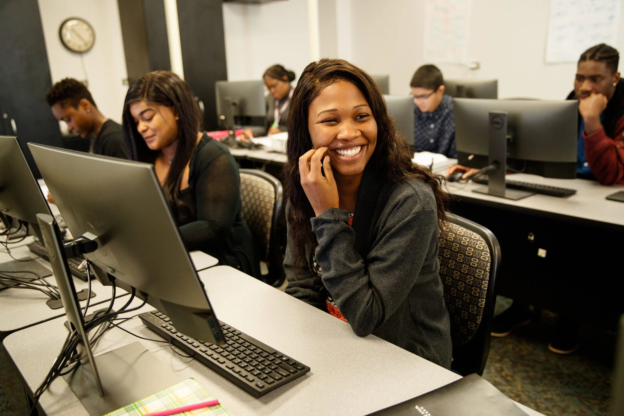 A student smiling while learning in a computer lab